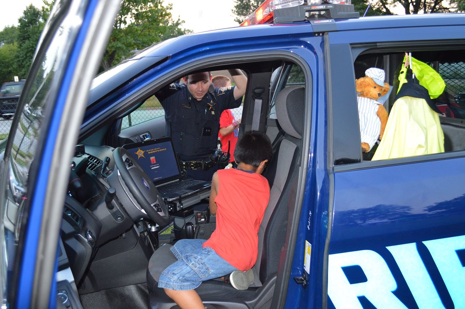 Children take turns exploring the driver's seat of a DuPage County Sheriff's vehicle during a National Night Out event at the Iowa Community Center, Aug. 2.